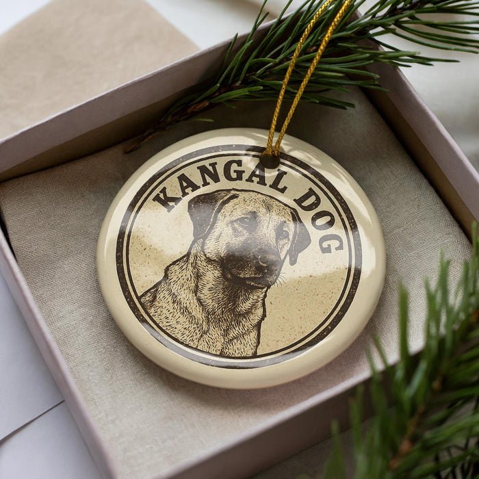 A circular ornament with a dog image and the text "KANGAL DOG" on it, placed in a box with pine branches.