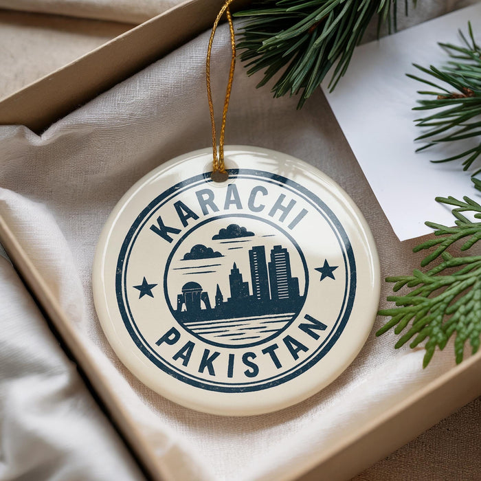 A circular ornament with the text "KARACHI PAKISTAN" printed on it, surrounded by a graphic of a city skyline.