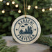 A circular ornament with the text "KARACHI PAKISTAN" and a graphic of a city skyline, hanging from a string.