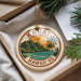 A circular ornament with the text "HAWAII US" and an illustration of a tropical landscape with mountains, palm trees, and a sunset.
