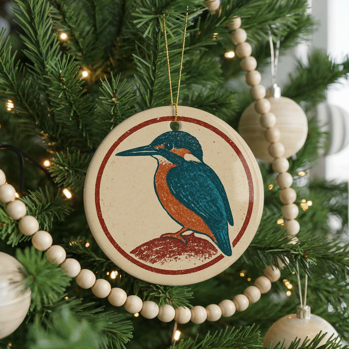 A Christmas tree decorated with ornaments, including a circular ornament featuring a bird design.