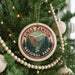 A Christmas tree decorated with ornaments, including a circular ornament with the text "Kings Canyon National Park" and a mountain landscape design.