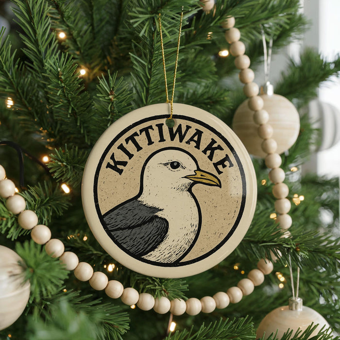 A Christmas tree decorated with ornaments, including a circular ornament with a bird image and the word "KITTIWAKE" written on it.