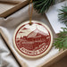 A circular ornament with a red and white design depicting a temple, hanging from a string.