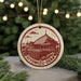 A circular ornament featuring a red and white illustration of a temple or pagoda, with the text "Kiyomizu-Dera" written around the edge.