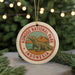 A circular ornament featuring a komodo lodo, a type of lizard, in a natural setting with mountains in the background, surrounded by Christmas lights.