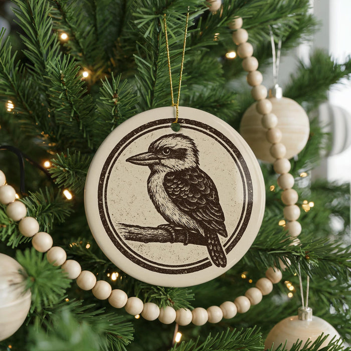 A Christmas tree decorated with ornaments, including a circular ornament featuring a kookaburra, and a string of wooden beads.