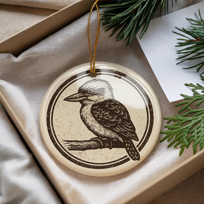 A circular ornament featuring a black and white illustration of a bird perched on a branch, hanging from a string.