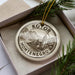 A circular ornament with the text "KOTOR MONTENEGRO" printed on it, surrounded by pine branches.
