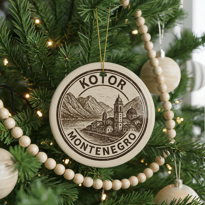 A Christmas tree decorated with ornaments, including a circular ornament with the text "KOTOR MONTENEGRO" and a landscape illustration.