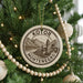 A Christmas tree decorated with ornaments, including a circular ornament with the text "KOTOR MONTENEGRO" and a landscape illustration.