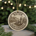 A circular ornament with the text "KOTOR MONTENEGRO" and an illustration of a mountain landscape, hanging from a string.