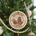 A Christmas tree decorated with ornaments, including a circular ornament with the text "KUNMING CHINA" and a traditional Chinese temple illustration.