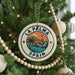 A circular ornament on a Christmas tree, featuring a palm tree and a castle, with the text "LA PALMA SPAIN" displayed on it.