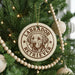 A circular ornament on a Christmas tree featuring a Labrador Retriever dog's face, with the text "Labrador Retriever" around the edge.