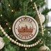 A circular ornament on a Christmas tree, featuring an image of the Lahore Mosque in Pakistan.