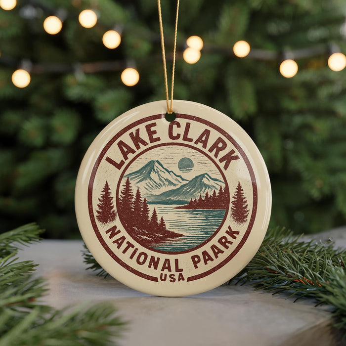 A circular ornament with the text "LAKECLARK NATIONAL PAARK USA" and a mountain landscape design, hanging from a string.