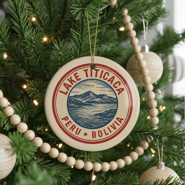 A circular ornament on a Christmas tree, featuring a mountain landscape and the text "LAKE TITICACA PERU BOLIVIA".