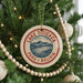 A circular ornament on a Christmas tree, featuring a mountain landscape and the text "LAKE TITICACA PERU BOLIVIA".