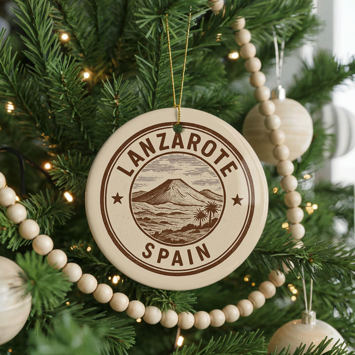 A circular ornament on a Christmas tree, featuring the text "LANZAROTE SPAIN" and a mountain landscape design.