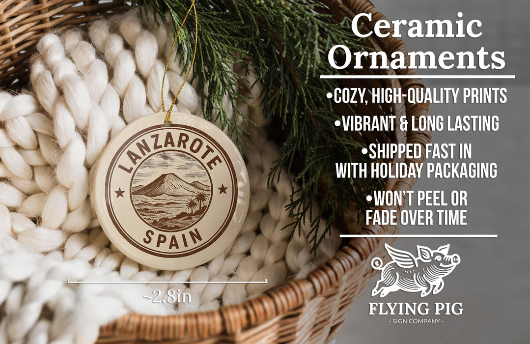 Ceramic ornaments, specifically a round ornament with the text "LANZAROTE SPAN" and a mountain design, hanging from a wicker basket.