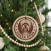 A Christmas tree decorated with ornaments, including a circular ornament with a dog's face and the text "LHASA APSO" printed on it.