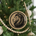 A Christmas tree decorated with ornaments, including a circular ornament featuring a lion's head design.