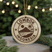 A circular ornament with the text "LOMBOK INDONESIA" and a graphic of a mountain, palm tree, and beach, hanging from a string.