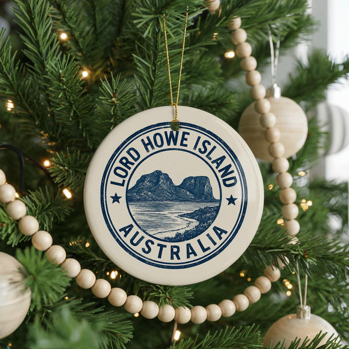 A Christmas tree decorated with ornaments, including a circular ornament with the text "LORD HOWE ISLAND AUSTRALIA" and a scenic image of a mountain and ocean.