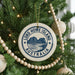 A Christmas tree decorated with ornaments, including a circular ornament with the text "LORD HOWE ISLAND AUSTRALIA" and a scenic image of a mountain and ocean.