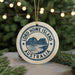 A round ornament with the text "LORD HOWE ISLAND AUSTRALIA" printed on it, featuring a mountain and ocean landscape.