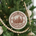 A Christmas tree decorated with ornaments, including a circular ornament with the text "LOUISVILLE KENTUCKY" and a cityscape illustration.