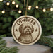 A circular ornament featuring a dog's portrait, with the text "LÖWCHEN" prominently displayed.