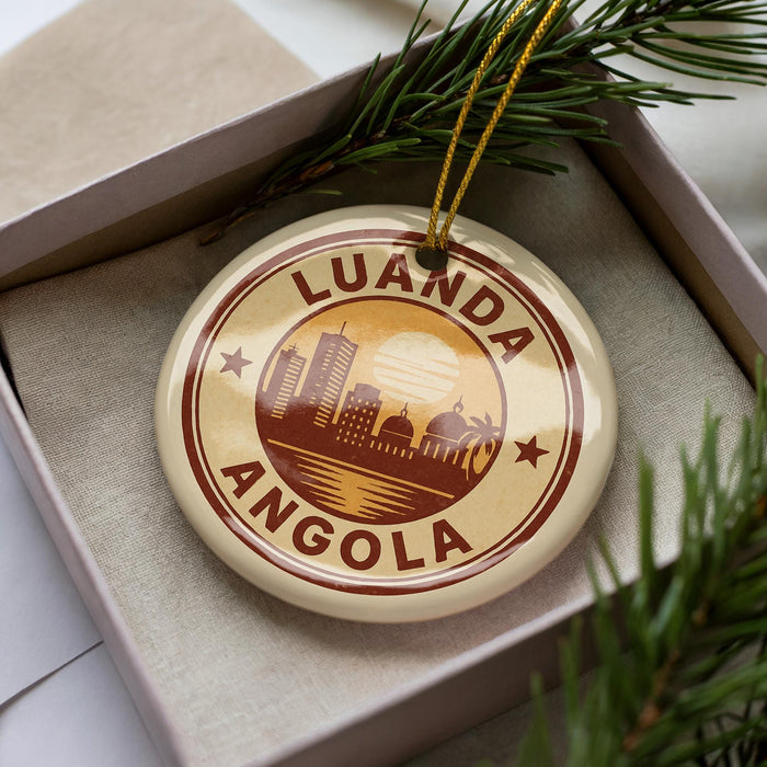 A circular ornament with the text "LUANDA ANGOLA" printed on it, surrounded by a decorative border.