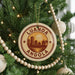 A Christmas tree decorated with ornaments, including a circular ornament with the text "LUANDA ANGOLA" and a cityscape design.