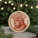 A round ornament with a monkey's face on it, hanging from a string.