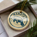 A circular ornament with the word "MANATEE" printed on it, featuring a stylized image of a manatee.