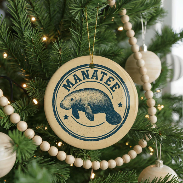 A Christmas tree decorated with ornaments, including a circular ornament with a manatee design and the word "MANATEE" written on it.