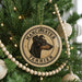 A Christmas tree decorated with ornaments, including a circular ornament with a dog's head and the text "MANCHESTER TERRIER" printed on it.