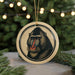 A circular ornament featuring a close-up of a mandrill's face, with a blurred background of a Christmas tree and twinkling lights.