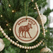 A Christmas tree decorated with ornaments, including a circular ornament with a graphic of a wolf and the text "MANED WOLF".