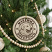 A Christmas tree decorated with ornaments, including a circular ornament with the text "Maremma Sheepdog" and a dog image.