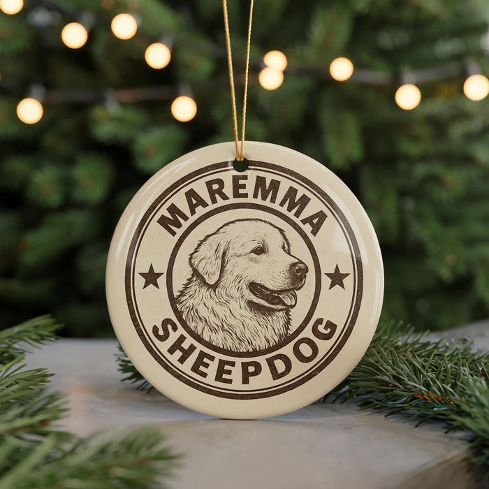 A circular ornament with the text "MAREMMA SHEEPDOG" and a graphic of a dog's head is displayed in front of a Christmas tree with twinkling lights.