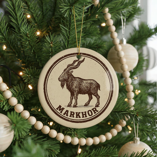 A Christmas tree decorated with ornaments, including a circular ornament with a goat illustration and the word "MARKHOR" written on it.