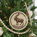 A Christmas tree decorated with ornaments, including a circular ornament with a goat illustration and the word "MARKHOR" written on it.