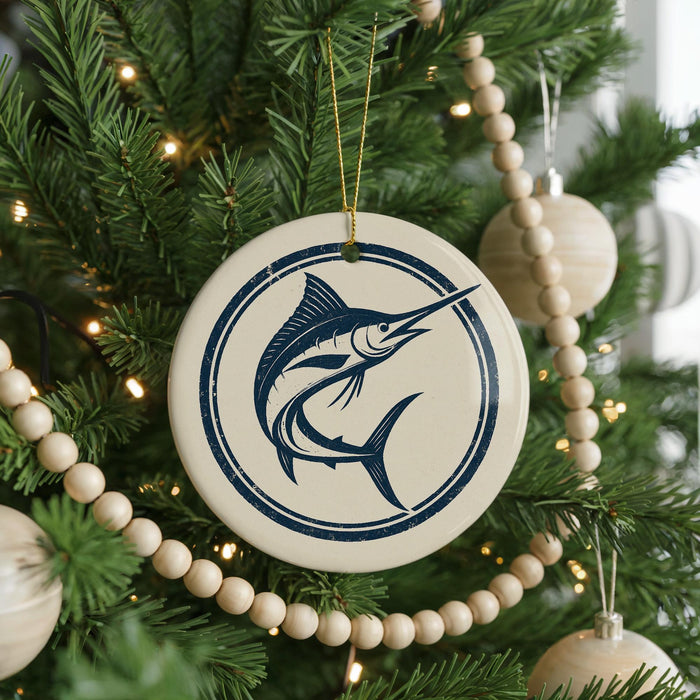 A Christmas tree decorated with ornaments, including a round ornament with a blue and white design featuring a fish.