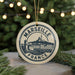 A circular ornament with the text "MARSEILLE FRANCE" and an illustration of a cityscape, hanging from a string.