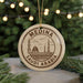 A circular ornament with the text "MEDINA SAUDI ARABIA" printed on it, featuring an illustration of a mosque and palm trees.