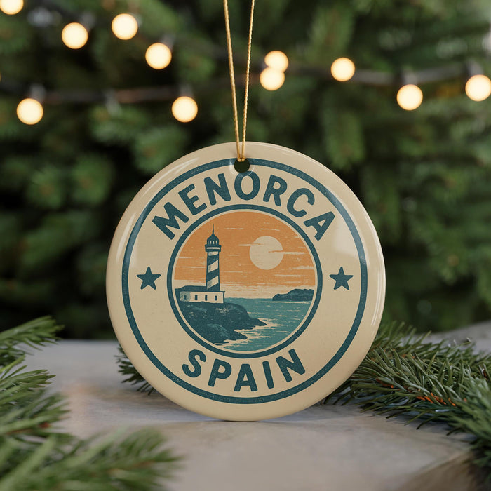 A circular ornament with the text "MENORCA SPAIN" and an illustration of a lighthouse on a beach, surrounded by Christmas lights and greenery.