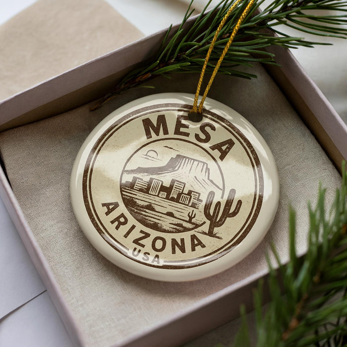 A circular ornament with the text "MESA ARIZONA USA" printed on it, surrounded by pine branches.